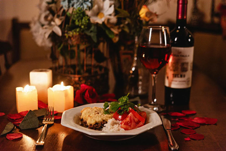 Candlelit dinner table with red wine, gourmet food, and rose petals β romantic aphrodisiac foods setting