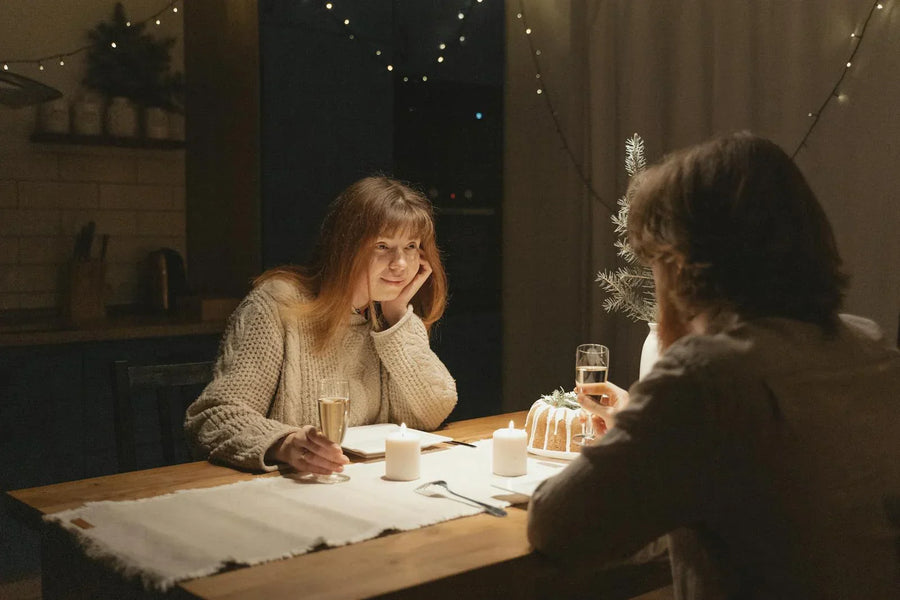Couple enjoying a cosy candlelit date night at home with champagne glasses