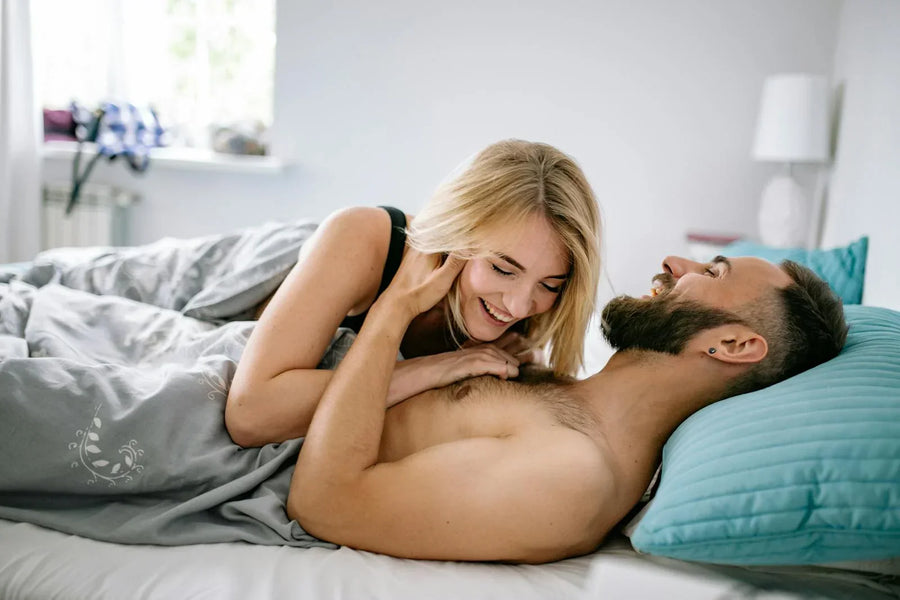 Couple laughing together in bed — joyful intimacy in a long-term relationship