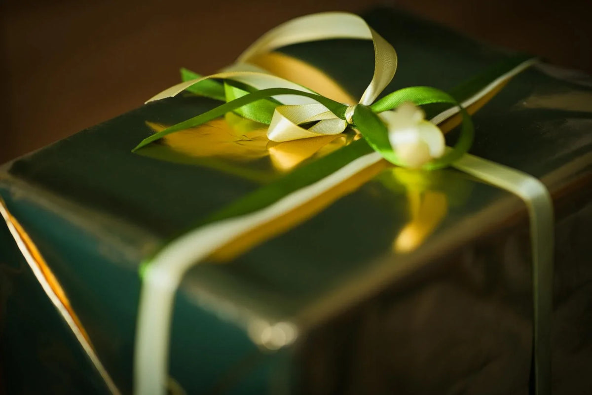 Wrapped Christmas gift with green paper and a ribbon