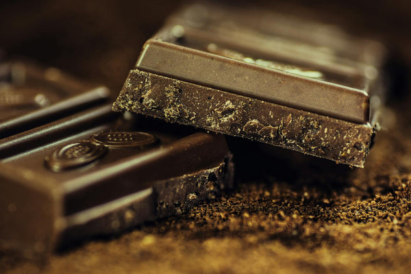 Dark chocolate bars dusted with cocoa powder — rich macro close-up of aphrodisiac chocolate