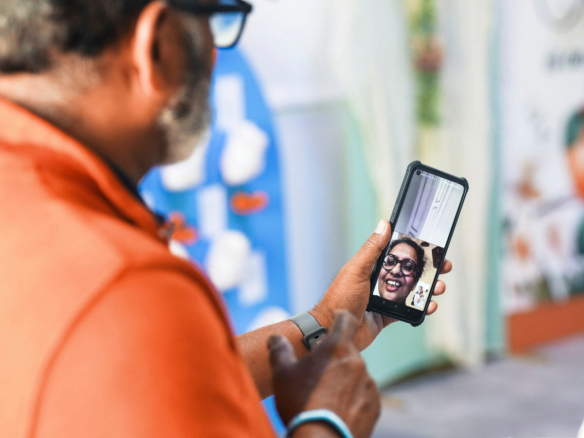 A man video calls a smiling woman on his phone