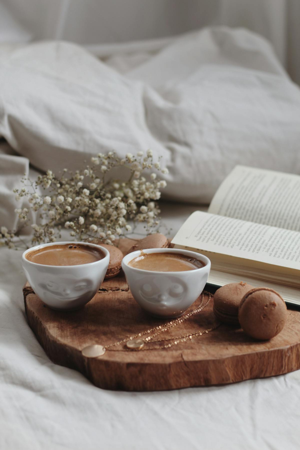 Two cups of coffee on a tray in bed — cosy intimate home date night
